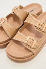 Sandalias negras con doble tira y hebillas doradas.