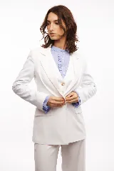 Blazer blanco entallado con cierre de un botón y tres botones en cada manga.