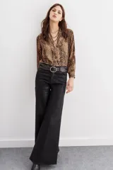 Camisa fluida con estampado reptil, escote redondo con apertura frontal y mangas largas terminadas en puño con botón.