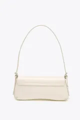 Bolso de hombro color crema con efecto acharolado, solapa con cierre magnético y asa ajustable.