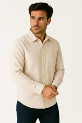 Camisa de manga larga color beige con cuello polo, cierre con botones y bolsillo en el pecho.