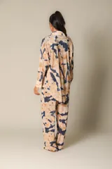 Camisa oversize de manga larga con cuello camisero y botones frontales. Estampado tie-dye en tonos beige y azul.