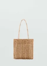 Bolso tipo shopper de paja color beige con detalle de anillas metálicas doradas y doble asa de cadena dorada.