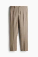 Pantalón de vestir color beige, corte slim fit, con cierre de botón, bolsillos laterales y bolsillos traseros ribeteados con botón.