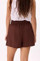 Short color beige de tela liviana, con cintura elastizada y lazo ajustable.