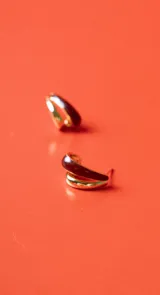 Aros pequeños tipo argolla, con diseño de doble banda, una dorada y otra esmaltada en color bordó.