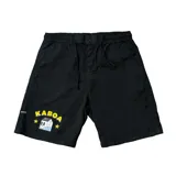 Bermuda de gabardina negra con cintura elástica y cordón de ajuste. Presenta un estampado gráfico en la pierna izquierda con la palabra "KABOA" en amarillo, un cráneo con una casa en lugar de la cara, y dos estrellas amarillas.