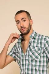 Camisa de manga corta con estampado a cuadros en tonos azul, rojo y blanco. Cierre con botones y tela ligera.