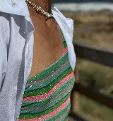 Bañador enterizo con estampado de rayas horizontales en tonos verde, rosa y plateado. Diseño de un solo tirante, con almohadillas extraíbles y forro completo.