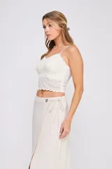 Top color crema de encaje elastizado con breteles finos ajustables, escote en V y copa interna formada.