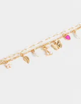 Pulsera dorada de doble cadena con dijes colgantes de flor rosa, hoja dorada, perla, cerezas con perlas, mariposa dorada, corazón fucsia y perla.