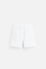 Bermuda regular fit negra confeccionada en tejido de lino. Cintura elástica ajustable con cordón y pliegues frontales. Bolsillos frontales y detalle de bolsillos traseros de plastrón.