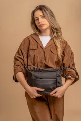 Bandolera de diseño moderno, color beige rosado, con correa regulable y bolsillo frontal con cierre.