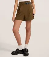 Short de sastrería color verde oliva, de corte recto y cintura alta. Presenta pliegues frontales y un detalle de medio cinturón con hebilla lateral.