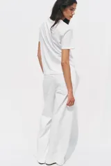 Camiseta blanca de manga corta y cuello redondo con estampado metalizado en el frente.
