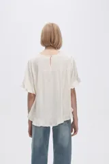Blusa color coral con cuello redondo y mangas cortas con volados.