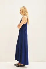 Vestido largo plisado color azul eléctrico, con breteles regulables, escote redondo en el frente y espalda baja. Confeccionado en viscosa con hilos de lurex a tono y moldería amplia.