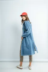 Tapado largo de jeans azul con bordado en la espalda, cuello camisero, bolsillos laterales y cierre frontal con botones.