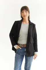 Blazer beige de tela agamuzada, corte recto y solapas clásicas.