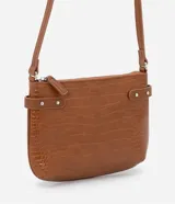 Bolso bandolera pequeño color marrón con textura de piel de cocodrilo, correa fina ajustable, cierre de cremallera y hebillas laterales decorativas.