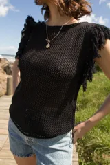 Musculosa tejida color marrón con diseño calado y flecos en los hombros.