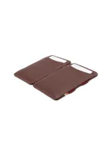 Billetera compacta de cuero negro con sistema mágico de correas elásticas para billetes y ranuras para tarjetas. Incluye protección RFID.