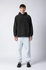 Buzo canguro marrón con capucha, confeccionado en frisa gruesa de algodón con recortes y calce oversize.