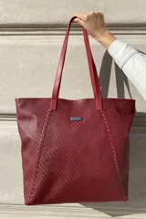 Bolso grande tipo tote de cuero color marrón con costuras decorativas en los laterales, forro interior con bolsillo para celular y bolsillo con cierre. Incluye bolsillo trasero con cierre y correas largas para colgar del hombro.