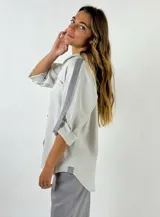 Camisa blanca de lino con cuello clásico, manga larga con tira abotonada para enrollar y bolsillo de parche en el pecho.
