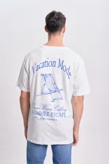 Remera blanca de manga corta con corte oversize y estampa azul en la espalda con una silla de playa y la frase "Vacation Mode".