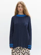Sweater azul marino de punto con cuello alto azul eléctrico, mangas largas con puños acanalados con rayas horizontales azules y logo bordado en el pecho.