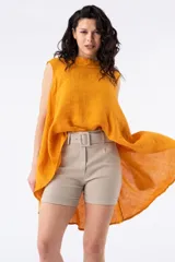 Short de tiro semi alto color beige con cinturón. Presenta bolsillos delanteros y falsos bolsillos traseros.