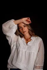 Camisa blanca de plumetí con cuello mao, mangas largas abullonadas con puños elásticos y cordón con borlas en el escote.