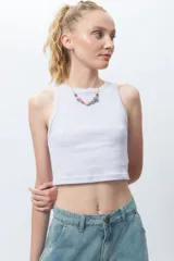 Top básico sin mangas, color blanco, con cuello a la base y diseño ajustado.