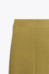 Pantalón negro de tiro alto confeccionado en tejido de punto elástico y flexible con trama compacta, mullida y opaca. Bajo acampanado.
