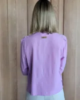 Camisa color beige claro con cuello con volados y mangas 3/4 abullonadas.