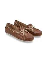 Mocasín color crema con textura de piel de cocodrilo, cordones de cuero marrón con punteras metálicas doradas y suela marrón de goma antideslizante.