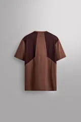 Camiseta marrón con paneles laterales en marrón oscuro, corte relaxed fit, cuello redondo y manga corta.