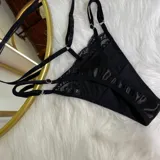 Conjunto de lencería de lycra y encaje negro, compuesto por un corpiño tipo bralette, tanga regulable, portaligas y ligas.