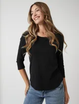 Remera de algodón negra de manga tres cuartos y cuello redondo.