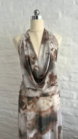 Vestido largo de microtul con estampado tie-dye en tonos rosa, verde y gris. Diseño con escote halter y espalda descubierta.