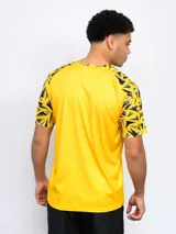Remera de entrenamiento del Club Atlético Peñarol, color negro con detalles geométricos en amarillo y gris en las mangas y cuello. Escudo del club bordado en el pecho.