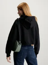 Buzo cropped negro con capucha, diseño relaxed y logo de Calvin Klein grabado en el pecho.