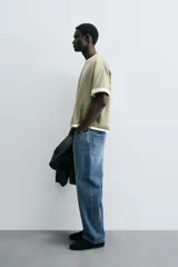 Pantalón de jean azul de tiro medio, corte flare, con cinco bolsillos y cierre frontal con cremallera y botón.