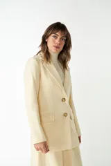 Blazer marrón de lana con solapas de muesca, cierre con dos botones dorados, bolsillos con solapa y forro interior a tono.