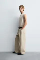 Pantalón de jean blanco, corte holgado y amplio en toda la pierna, tiro medio, tejido ligero, cinco bolsillos, efecto lavado y cierre frontal con cremallera y botón.