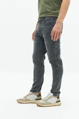 Jean slim azul oscuro, tiro medio, con pasacintos y confeccionado en 98% algodón y 2% spandex.
