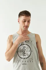 Musculosa gris con estampado de palmeras, la frase "Summer Beachside 1976" y el logo de Mistral.