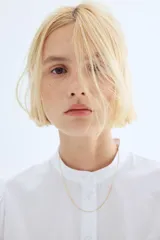Blusa blanca de algodón con cuello mao y botones. Manga abullonada al codo con broderie tono sobre tono y puños festoneados.