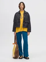 Campera de jean marrón claro con flecos en el pecho y mangas.